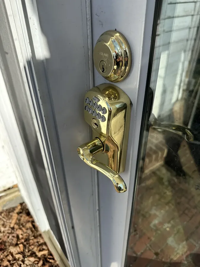 A brass keypad deadbolt and lever handle on an exterior door