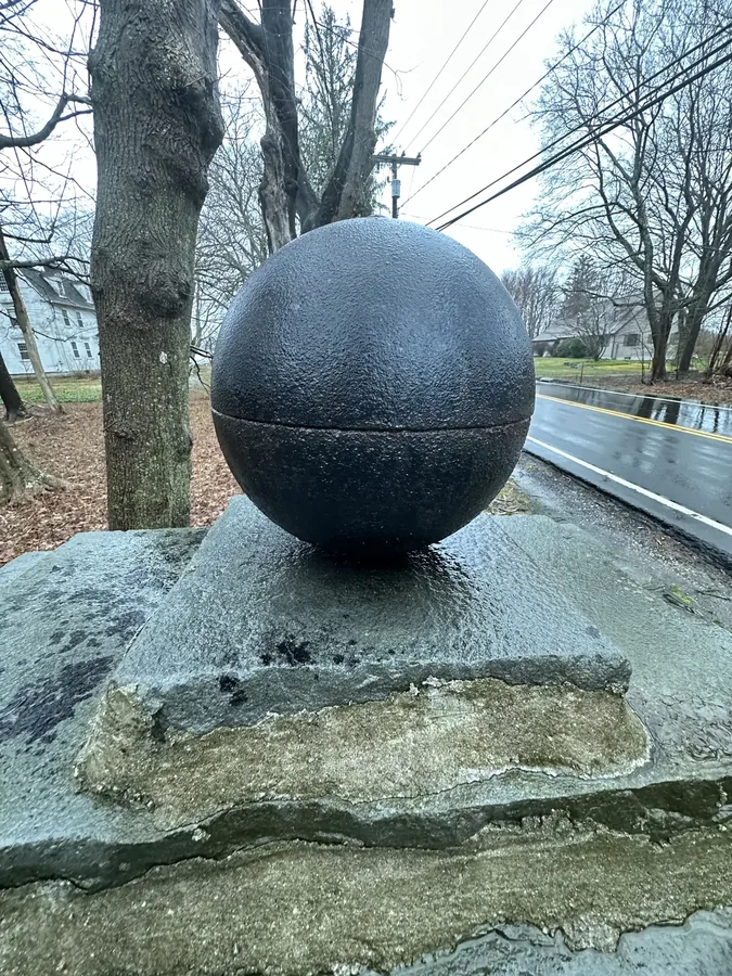A cannonball mounted on a stone pier at the property entrance