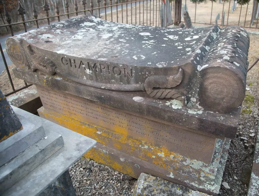 A stone tomb inscribed CHAMPION, enclosed by a wrought-iron fence at Westchester Cemetery