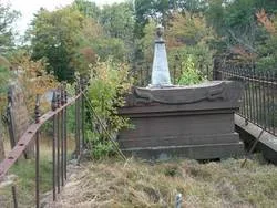 A wider view of the Champion family tomb among autumn foliage at Westchester Cemetery