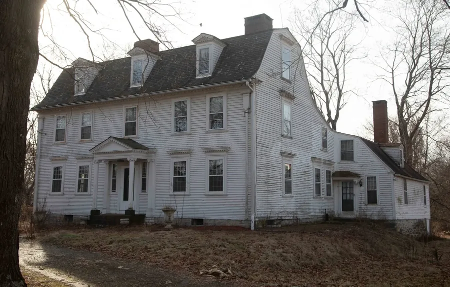 The full front of the house in winter, bare trees and low afternoon light