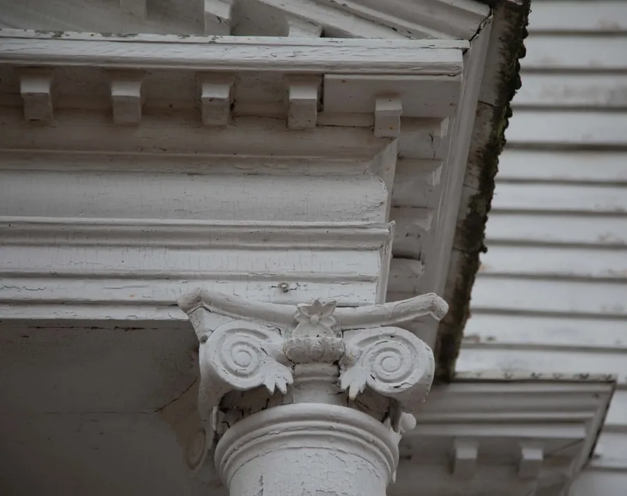 A close-up of one of the portico's carved Ionic column capitals, with scroll volutes and a central rosette