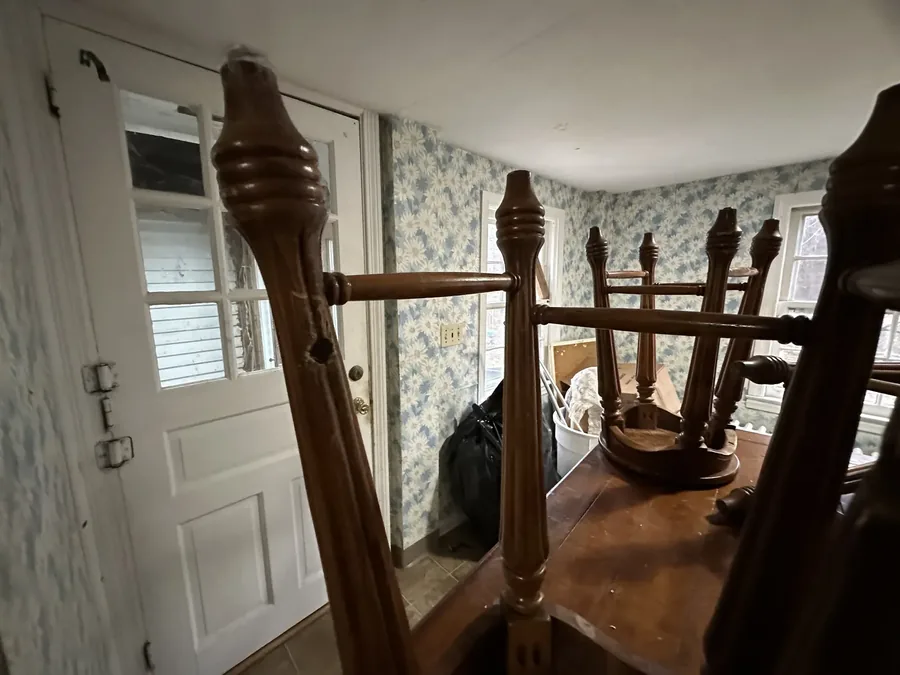 Turned wooden bedposts and table legs, salvaged and set aside during the house's clean-out