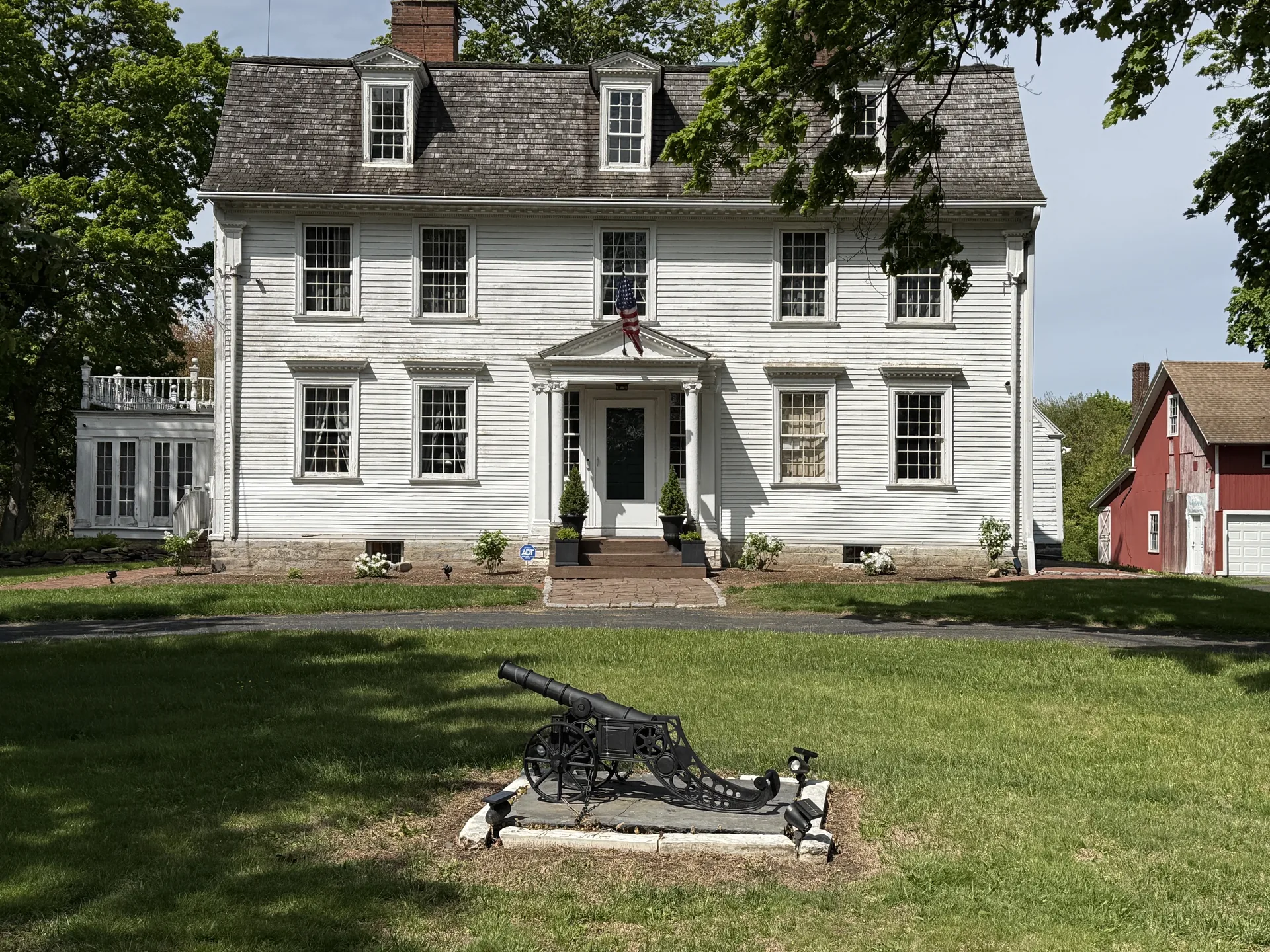 The General Henry Champion House today, freshly painted with bunting, cannon, and barn visible